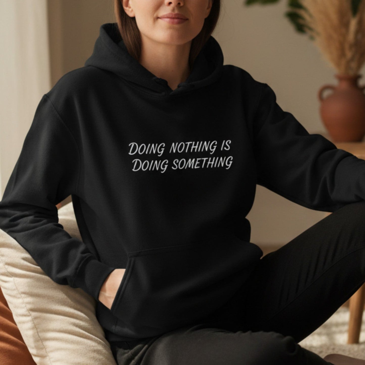 Black women's pullover hoodie with Doing Nothing Is Doing Something — cozy self-care gift, white HTV print, Canadian-made fleece