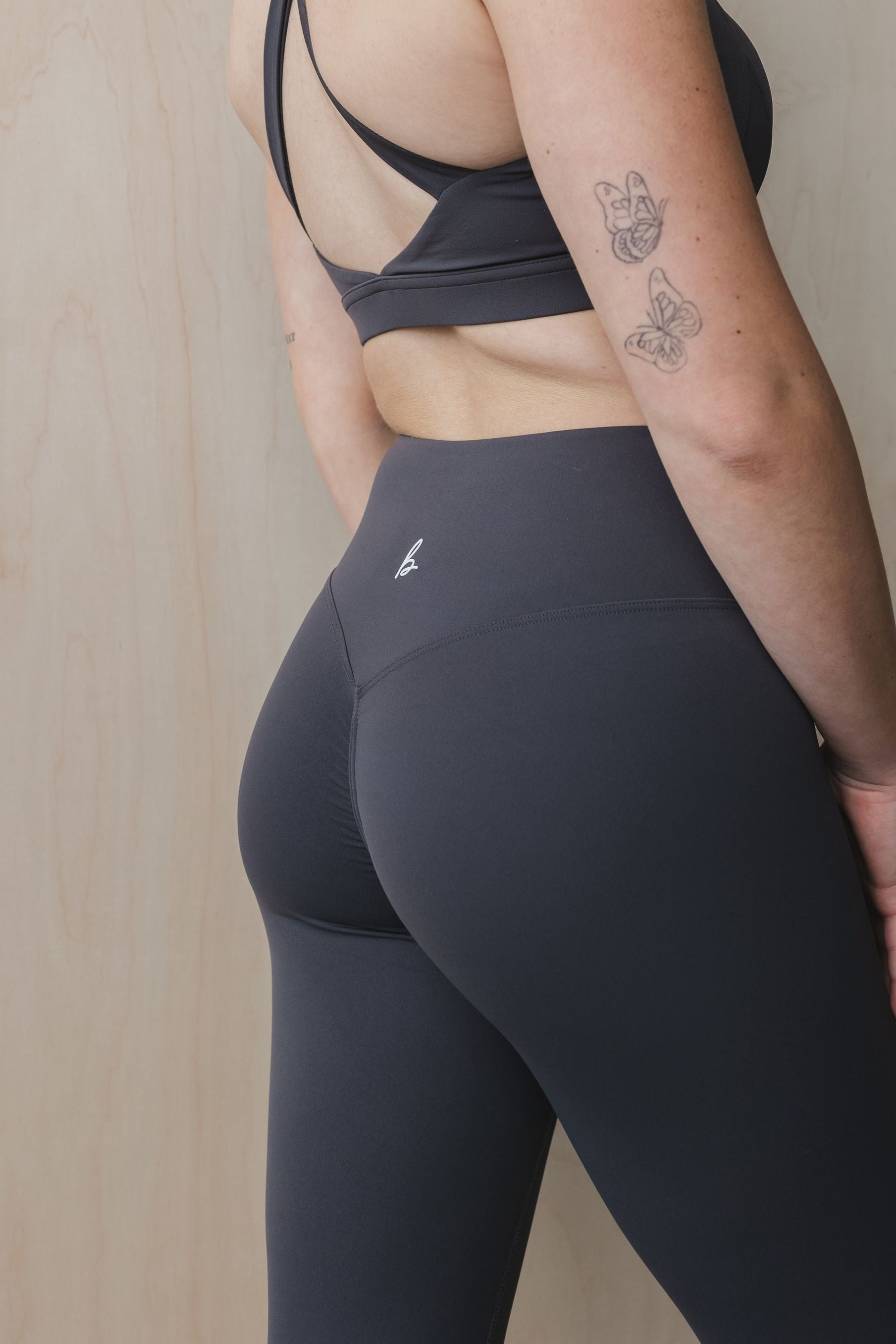 close up back view of a woman wearing 27 inch fight or flight leggings in midnight blue for the gym and studio wear