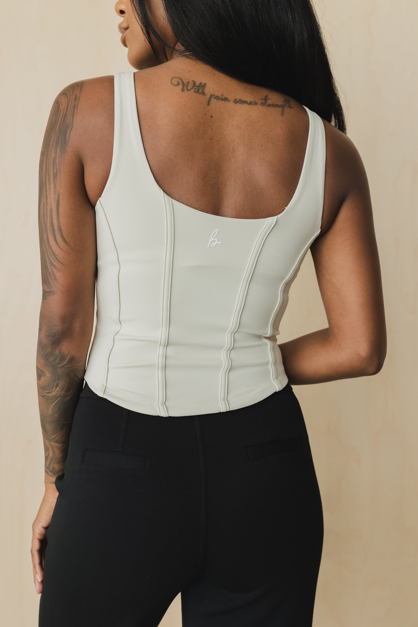 back view of a woman wearing a soft corset waist cincher in bone white for casual wear