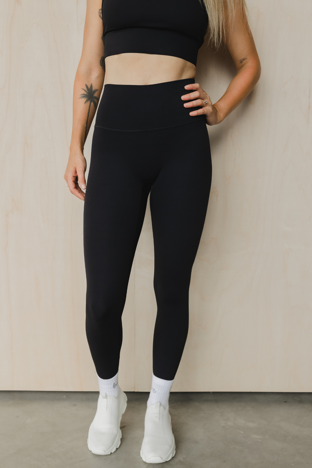 front view of a woman wearing 27 inch tall barely there leggings in black for high impact training and everyday wear