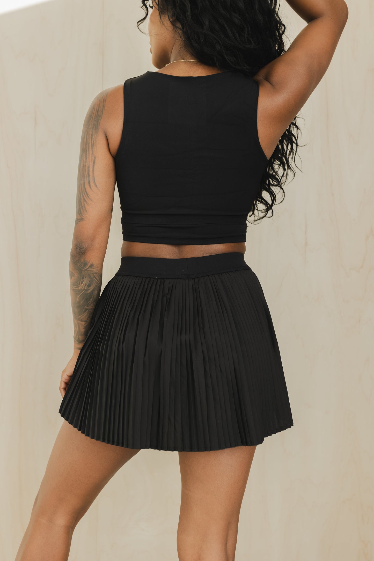 back view of a woman wearing a sweetheart tank top in black for yoga and activewear