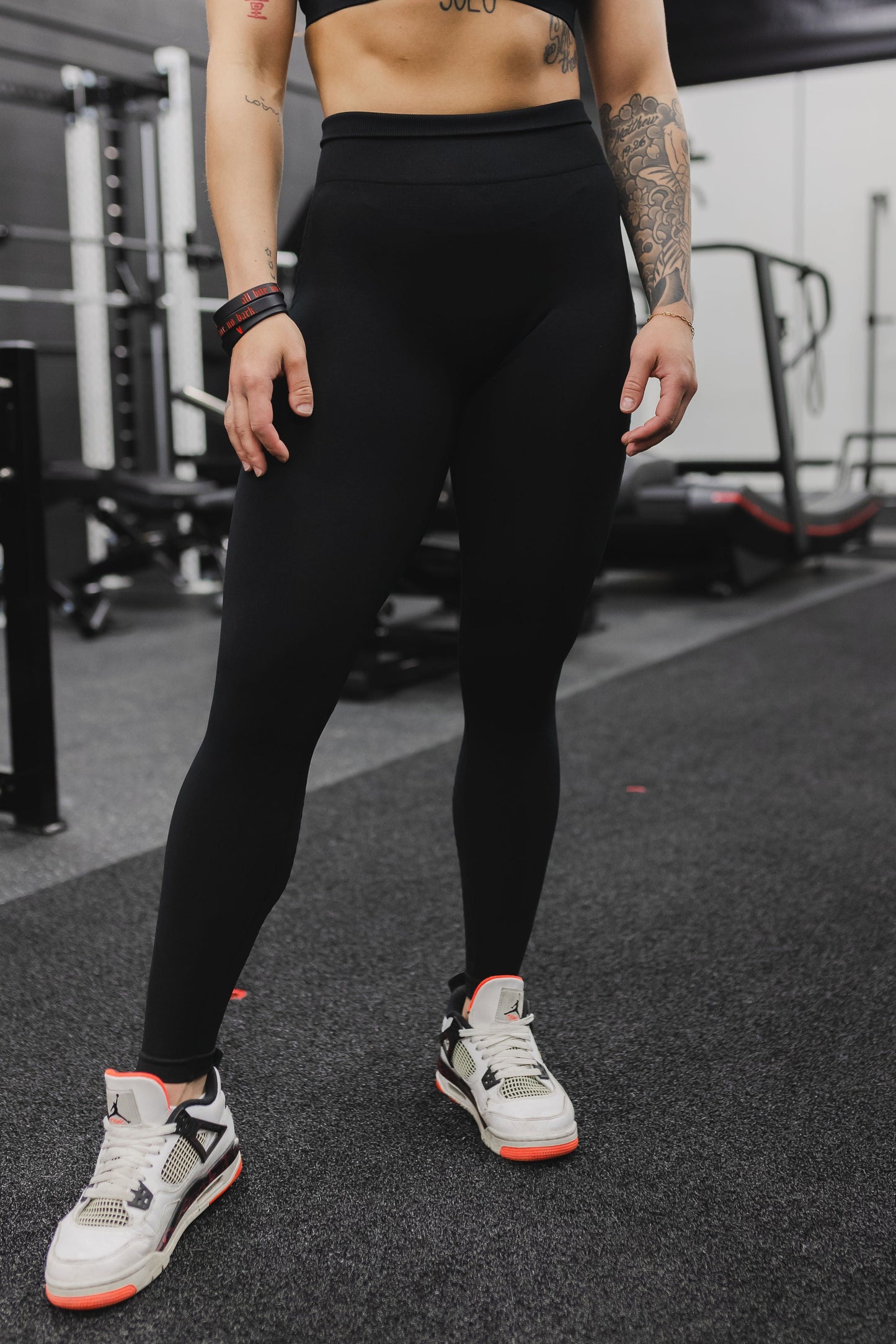 zoomed in front view of a woman wearing mini scrunch leggings in black for high impact training and everyday wear