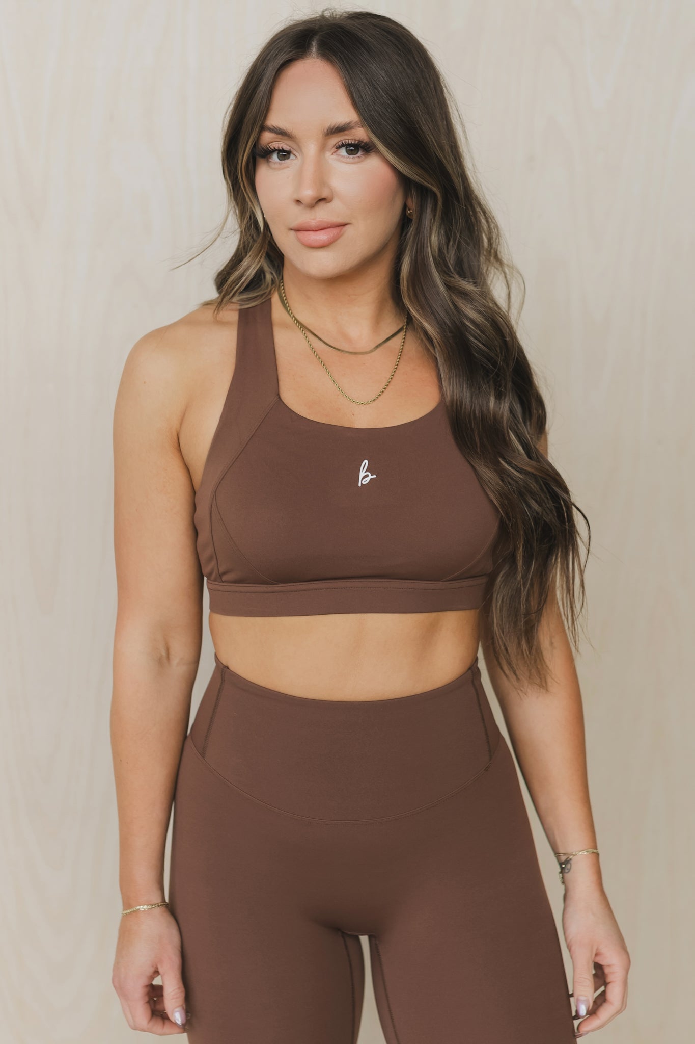 front view of a woman wearing a Fight or Flight high-support sports bra in caramel brown for yoga and fitness