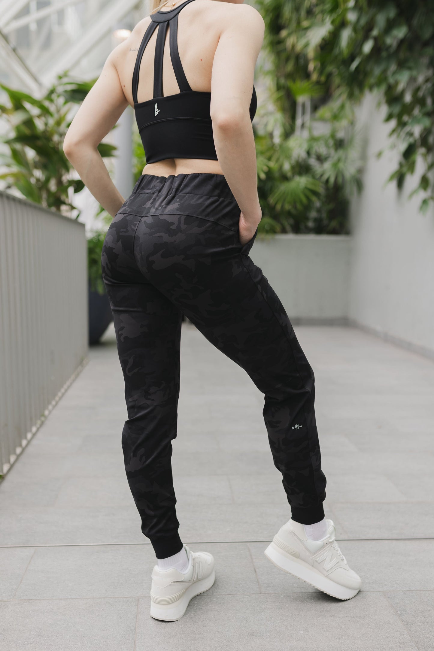 side back view of a woman wearing cuffed ankle jogger in black camo for streetwear and everyday wear