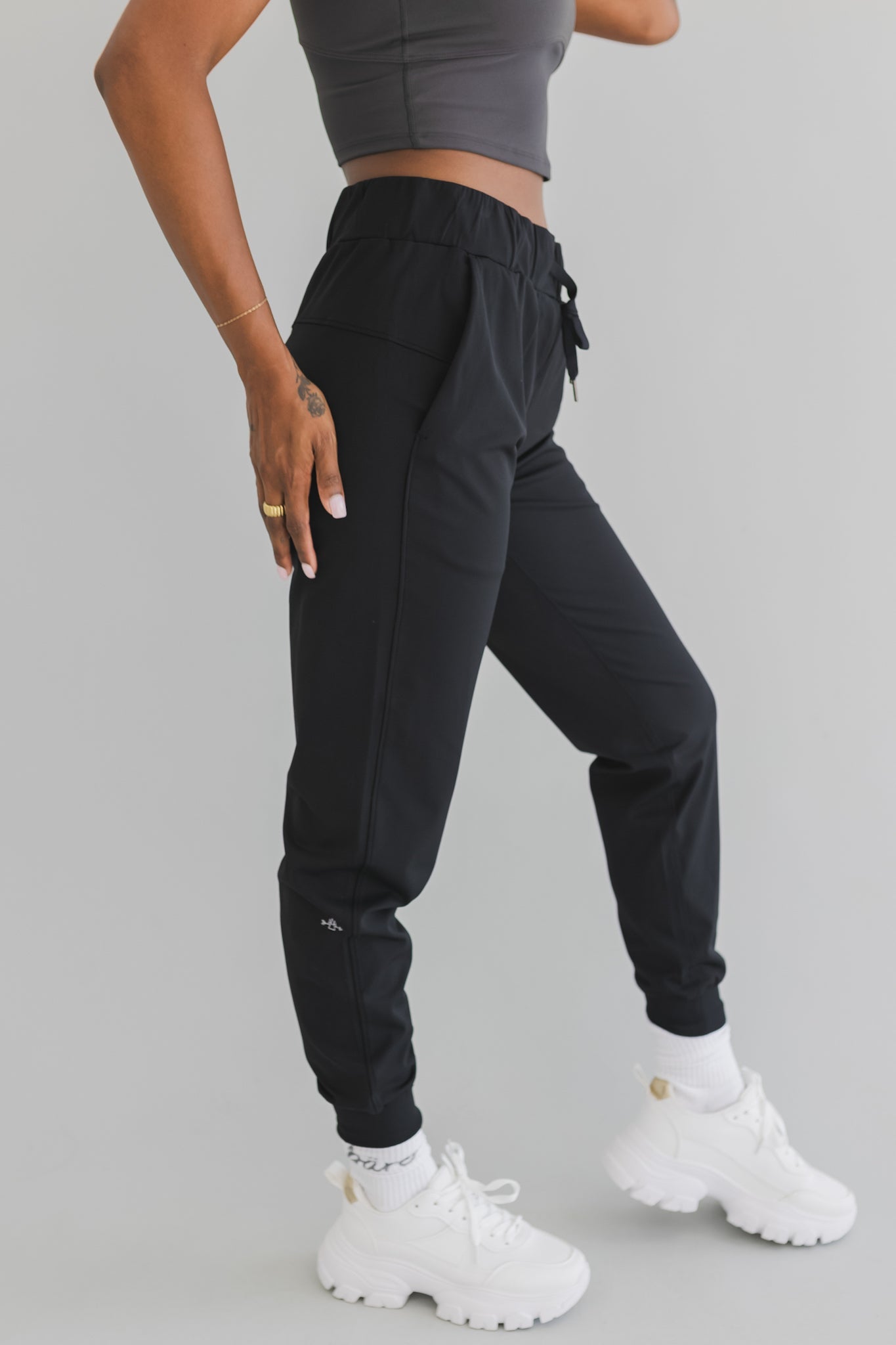 close up side view of a woman wearing cuffed ankle jogger in black camo for streetwear and everyday wear