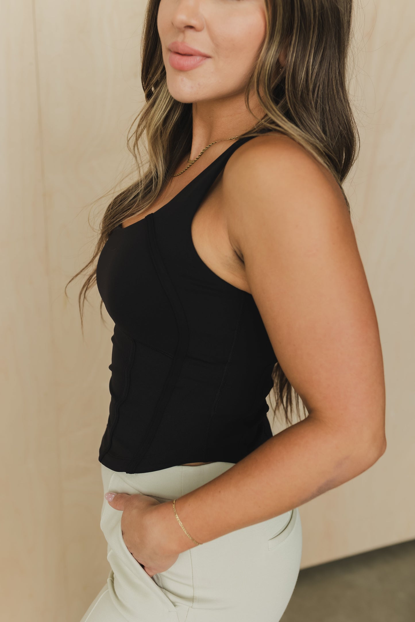 side view of a woman wearing a soft corset waist cincher in black for casual everyday wear