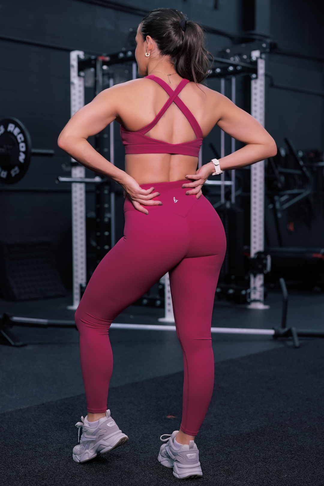 back view of a woman wearing 27 inch fight or flight leggings in jazzberry for the gym and high performance training