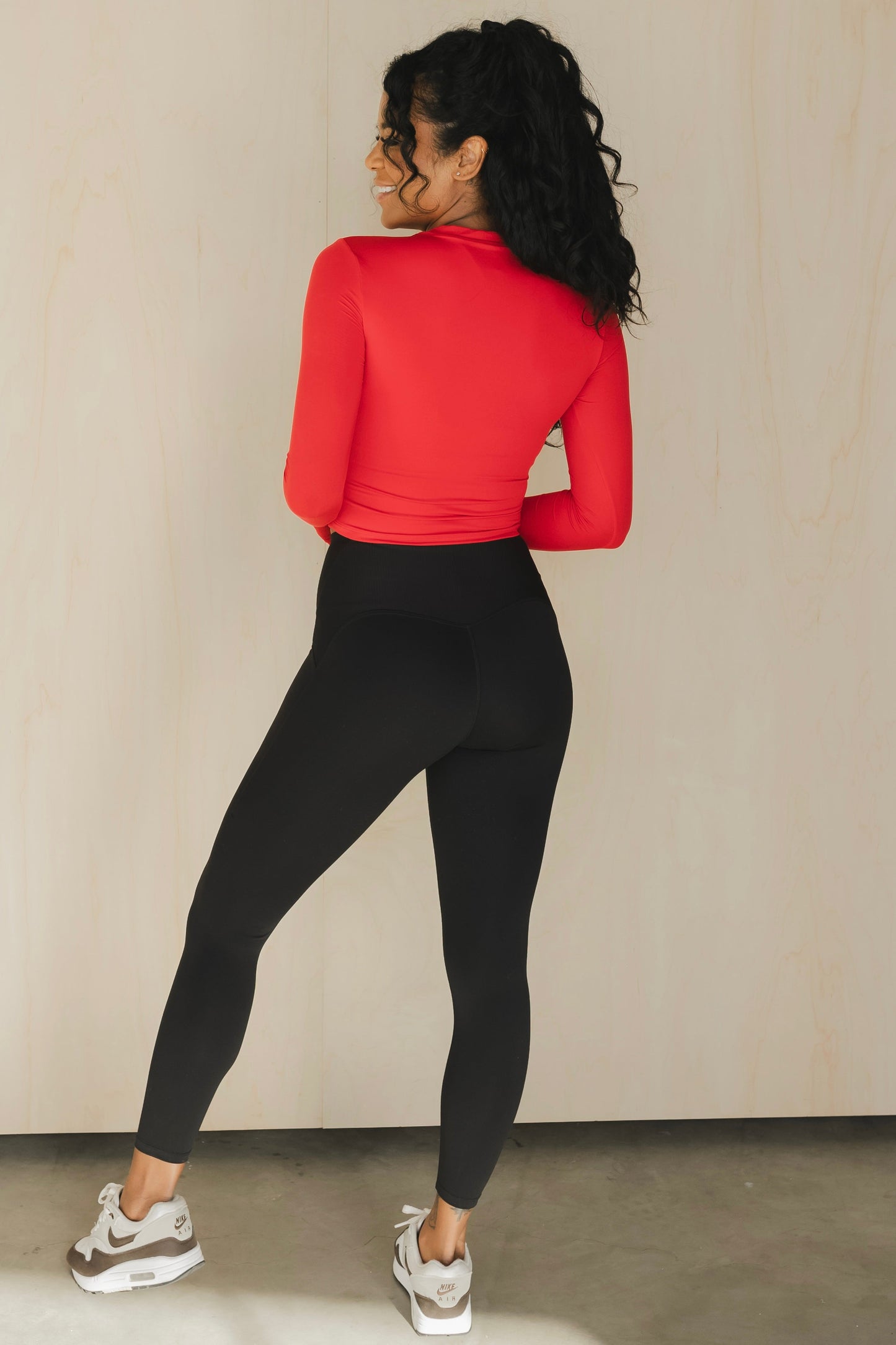 back view of a woman wearing 25 inch elevation leggings in black for the gym and everyday activewear