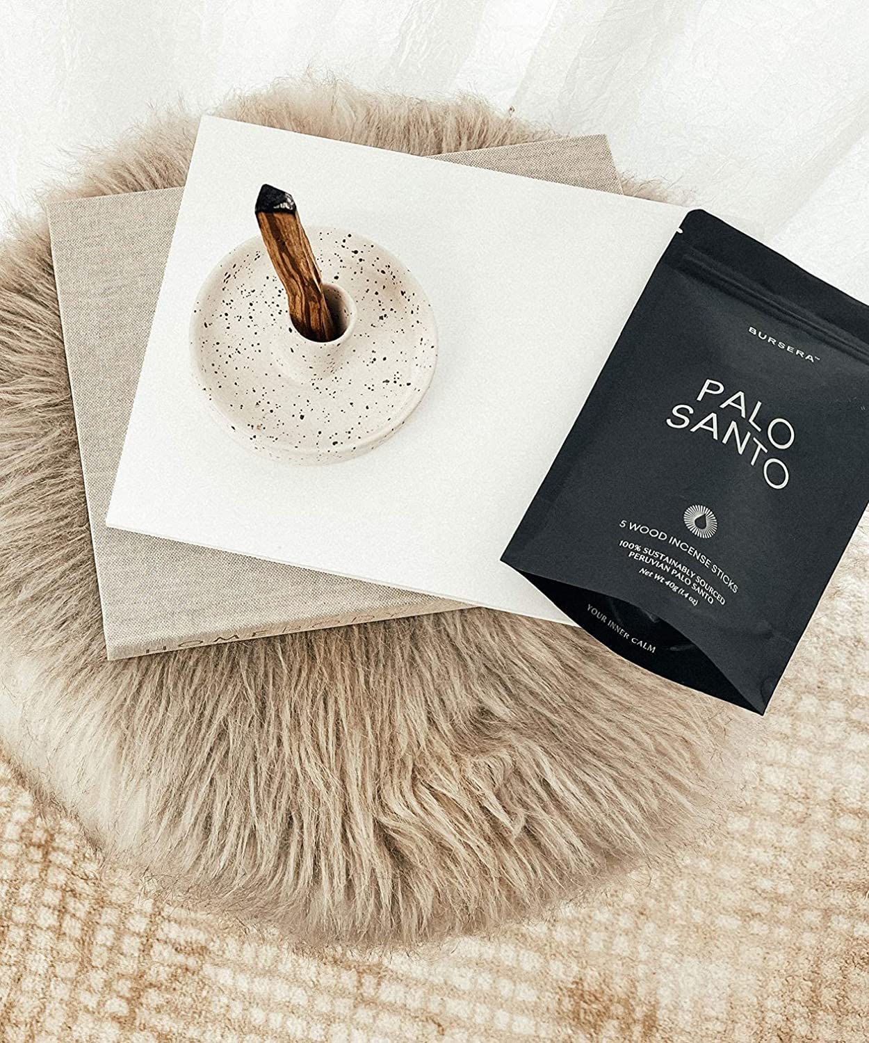 Palo Santo incense sticks in a black packaging on a textured surface