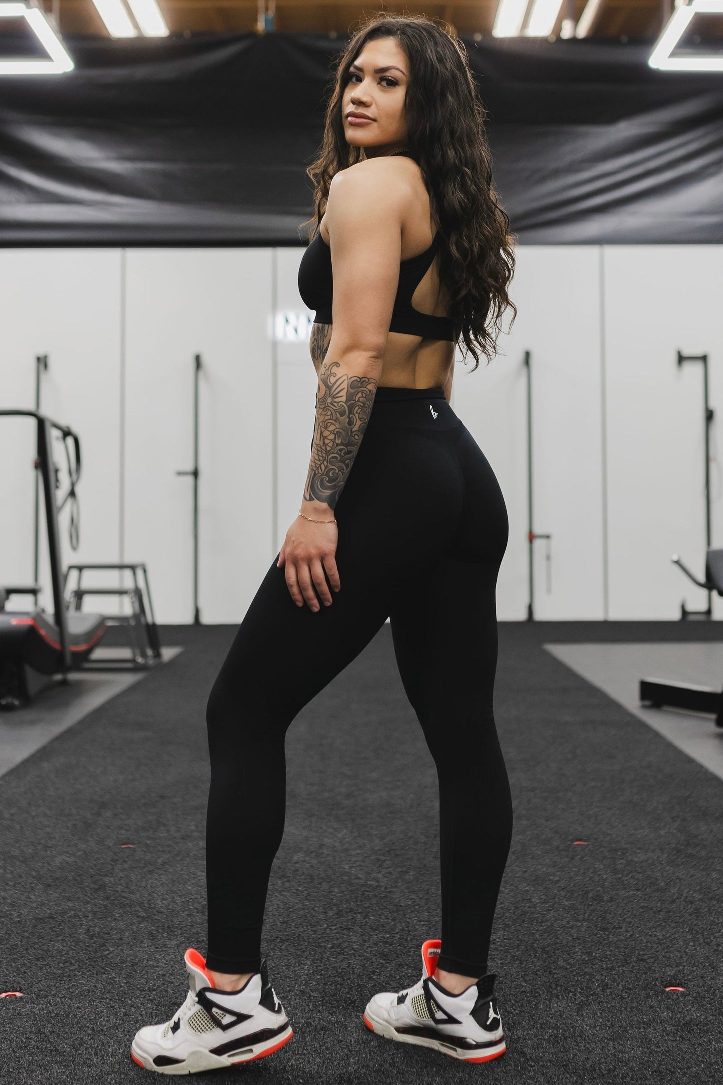 side view of a woman wearing mini scrunch leggings in black for high impact training and everyday wear