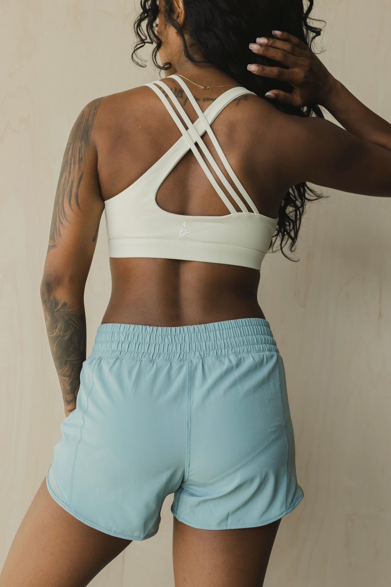 back view of woman wearing Ready for It shorts in hint of azure blue for workouts and casual wear