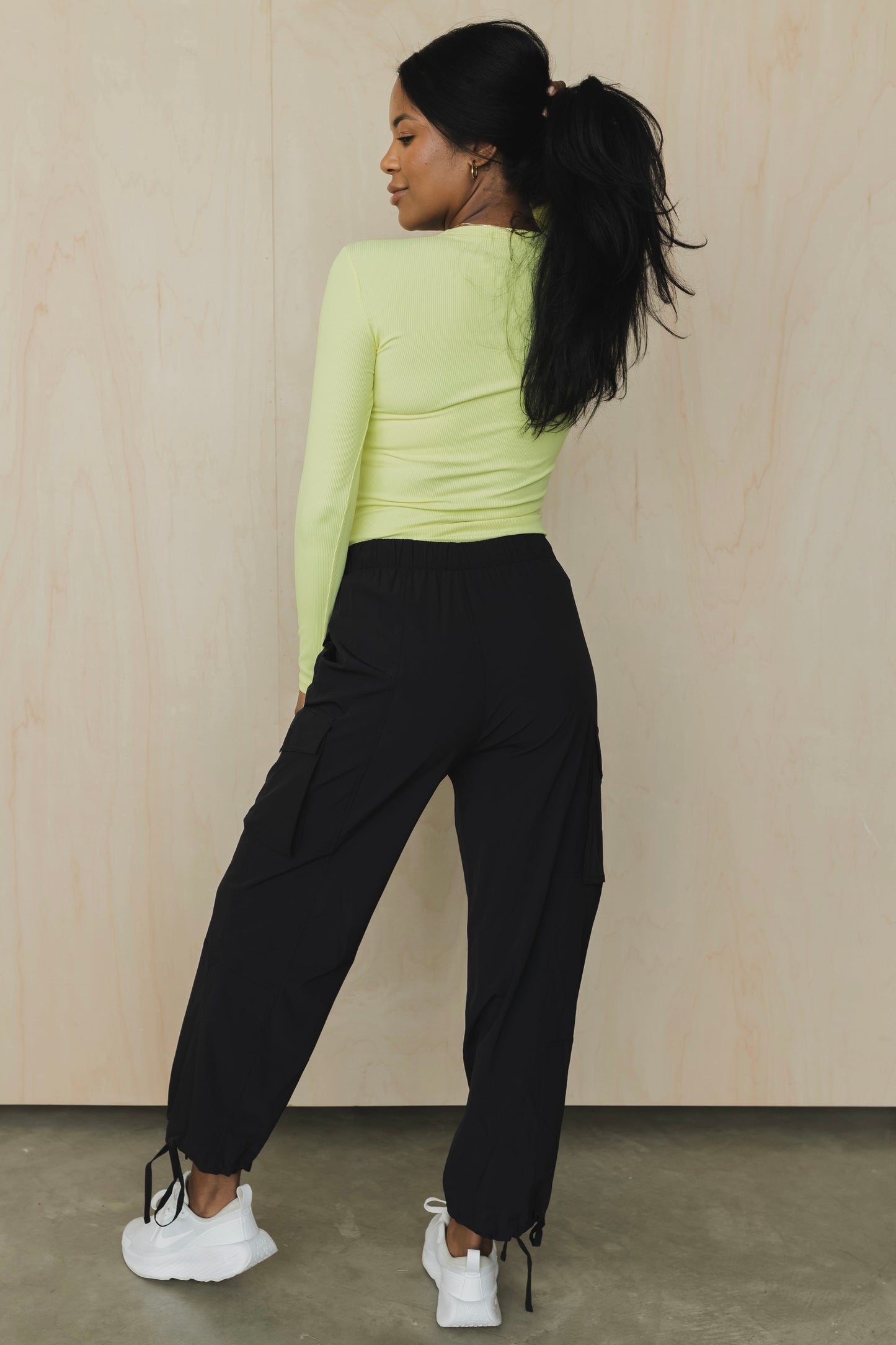 zoomed out back view of a woman wearing cargo pant in black for streetwear and versatile everyday styling