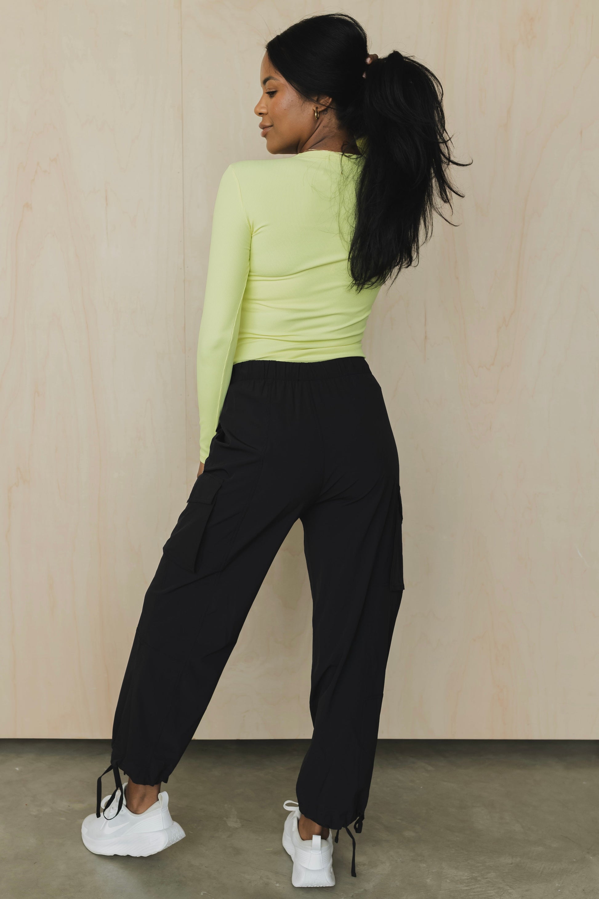 zoomed out back view of a woman wearing cargo pant in black for streetwear and versatile everyday styling