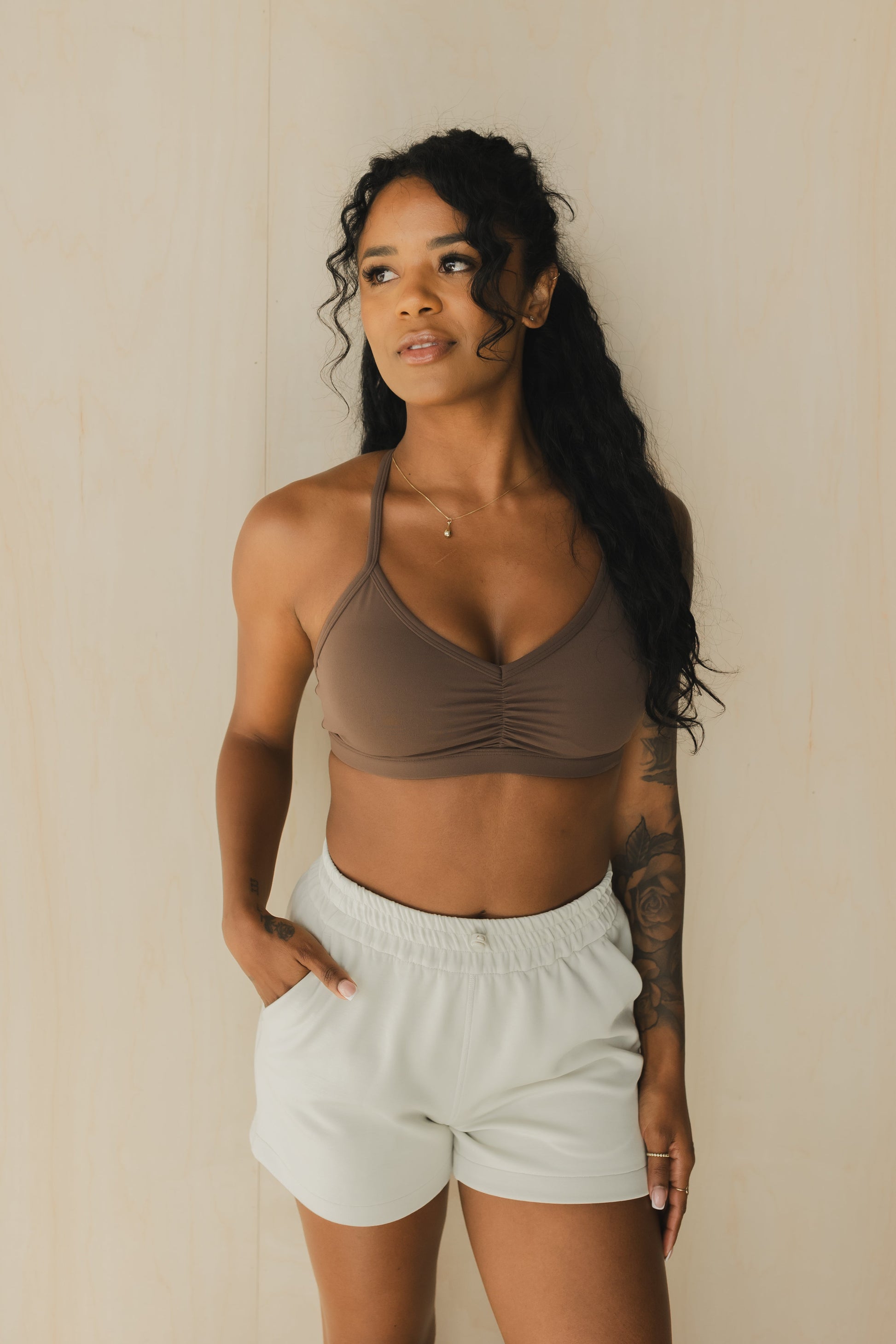 zoomed out view of a woman wearing a mini scrunch bra in dusty brown for yoga and summer workouts
