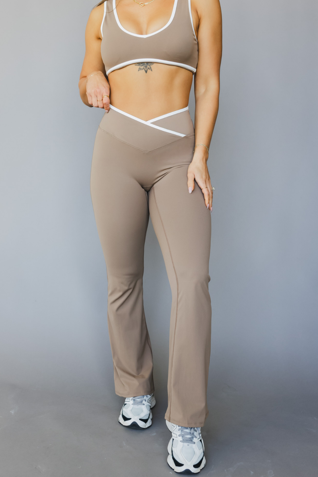 full view of a woman wearing flare leggings in sable brown with white trim for pilates and everyday styling