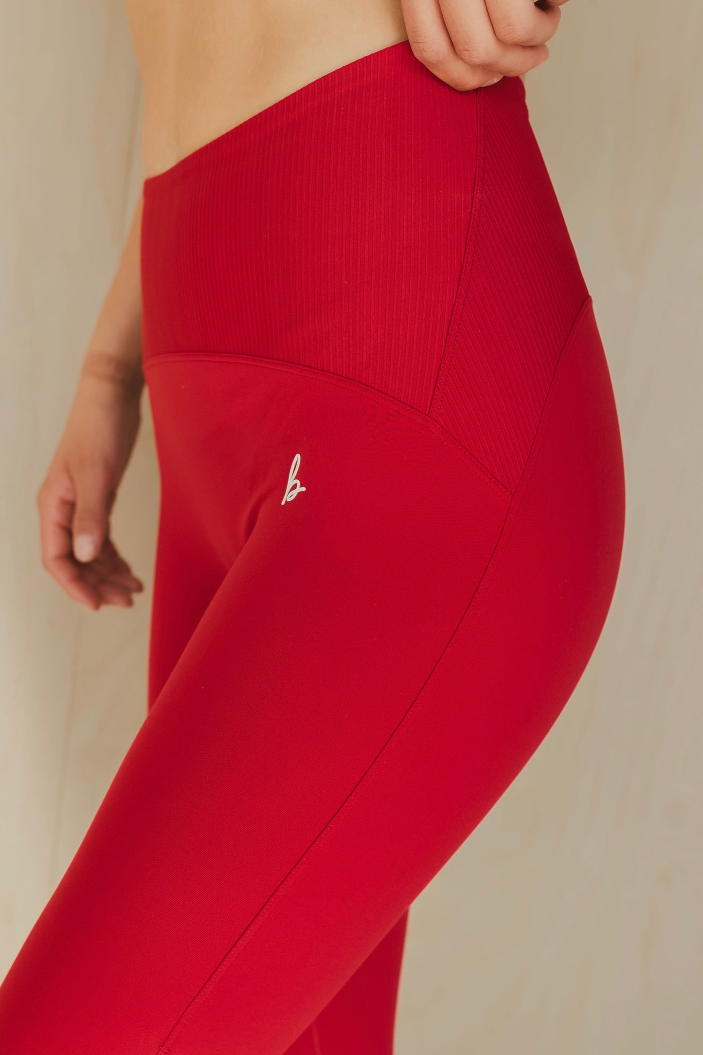 side view of a woman wearing 25 inch elevation leggings in royal crimson for pilates and high performance training