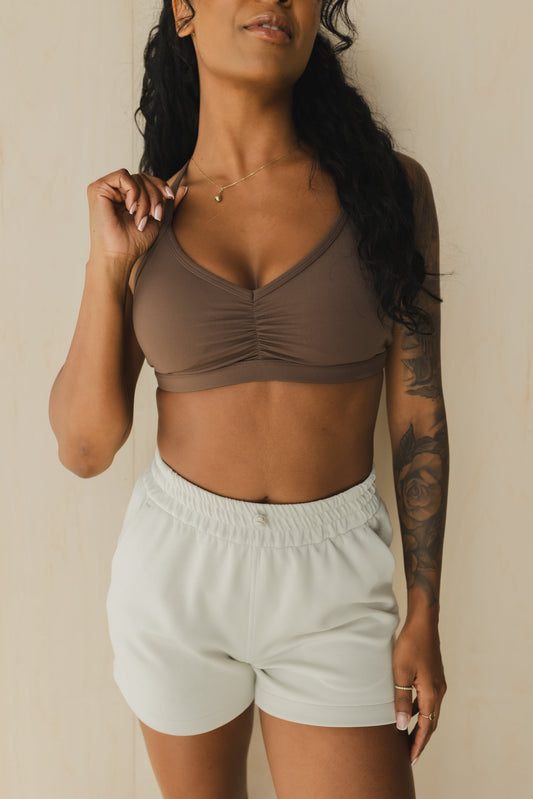 front view of a woman wearing a mini scrunch bra in dusty brown for yoga and summer workouts