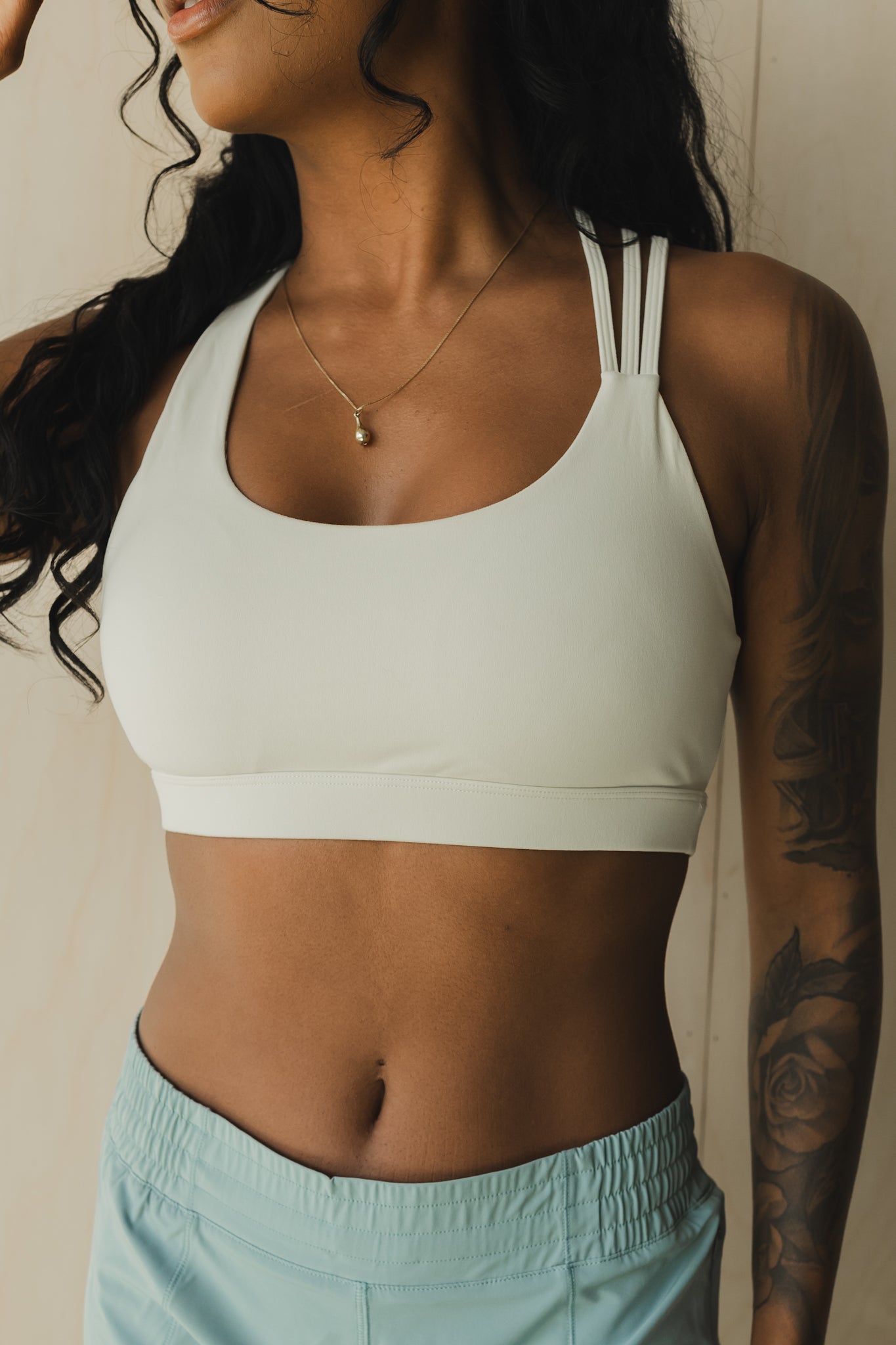 close up view of a woman wearing S.F. V3 sports bra in off white for pilates and low impact training
