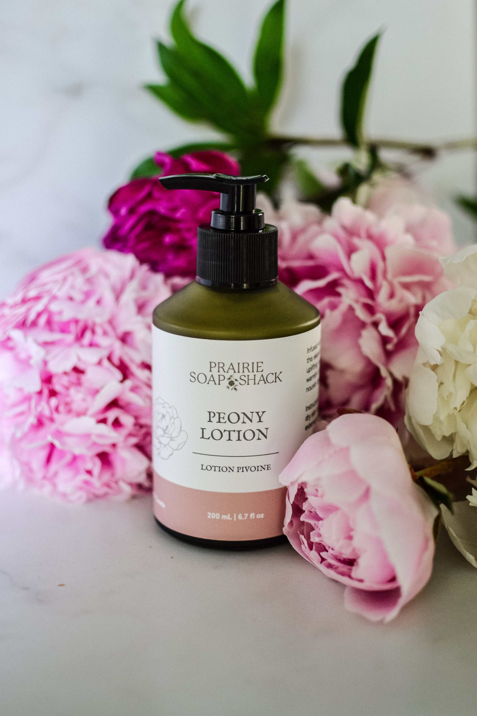 Natural peony and bergamot body lotion close-up showing bottle and texture detail