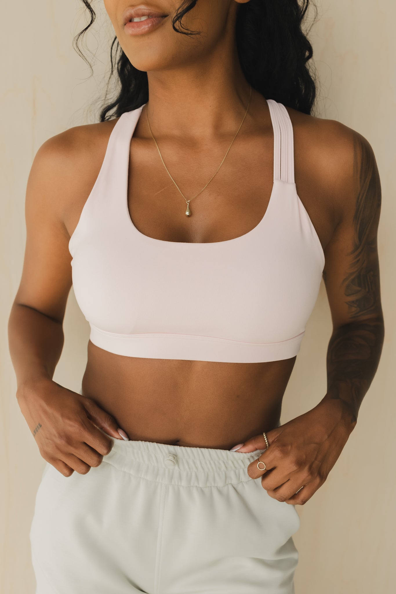 close up view of a woman wearing S.F. V3 sports bra in pink lemonade for yoga and studio workouts