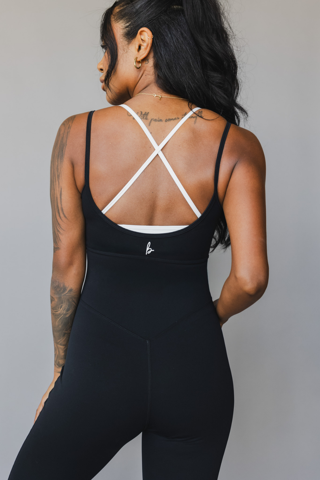 close up back view of a woman wearing tina bodysuit in black for yoga and studio wear