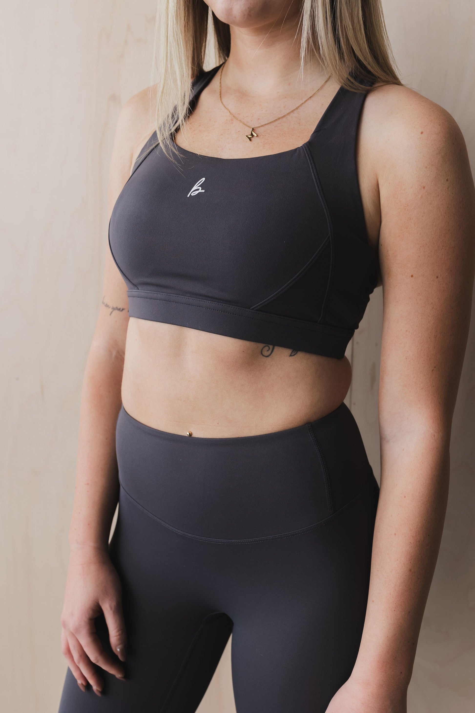front view of a woman wearing a Fight or Flight high-support sports bra in graphite for yoga and fitness