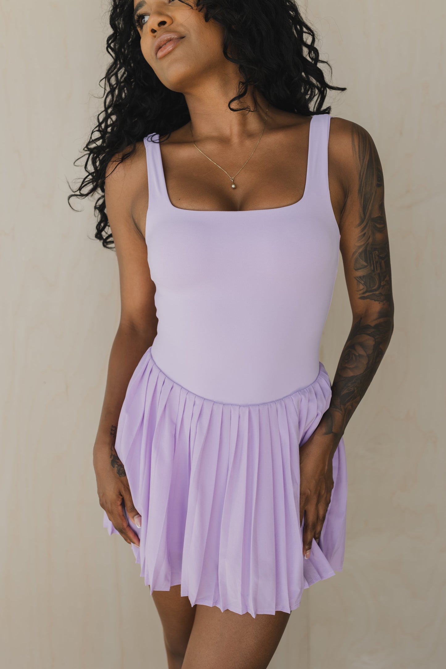 front view of woman wearing street to Court activewear dress in lilac purple with built-in bra and pocket for tennis and yoga