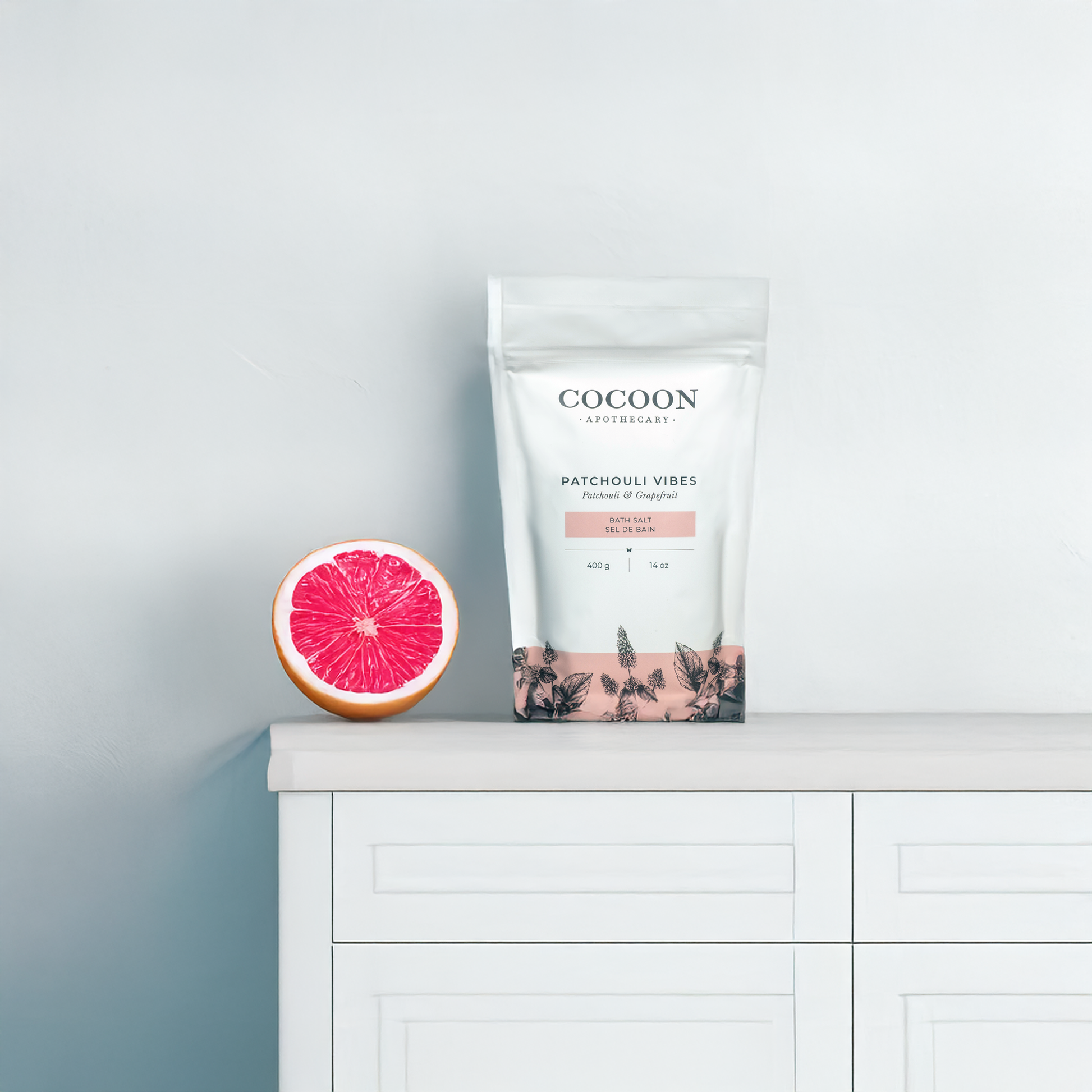 patchouli vibes bath salts product packaging on a white surface with a pink grapefruit slice