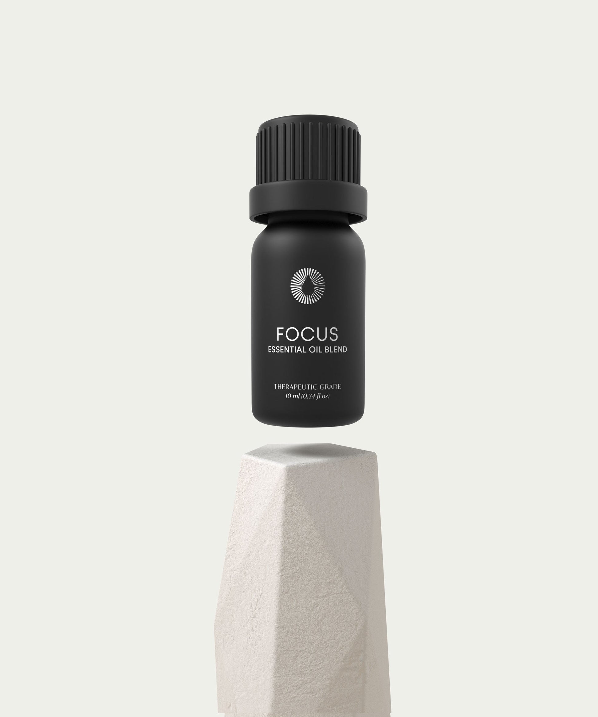 essential oil blend aromatherapy bottle labeled 'Focus' on a light gray background