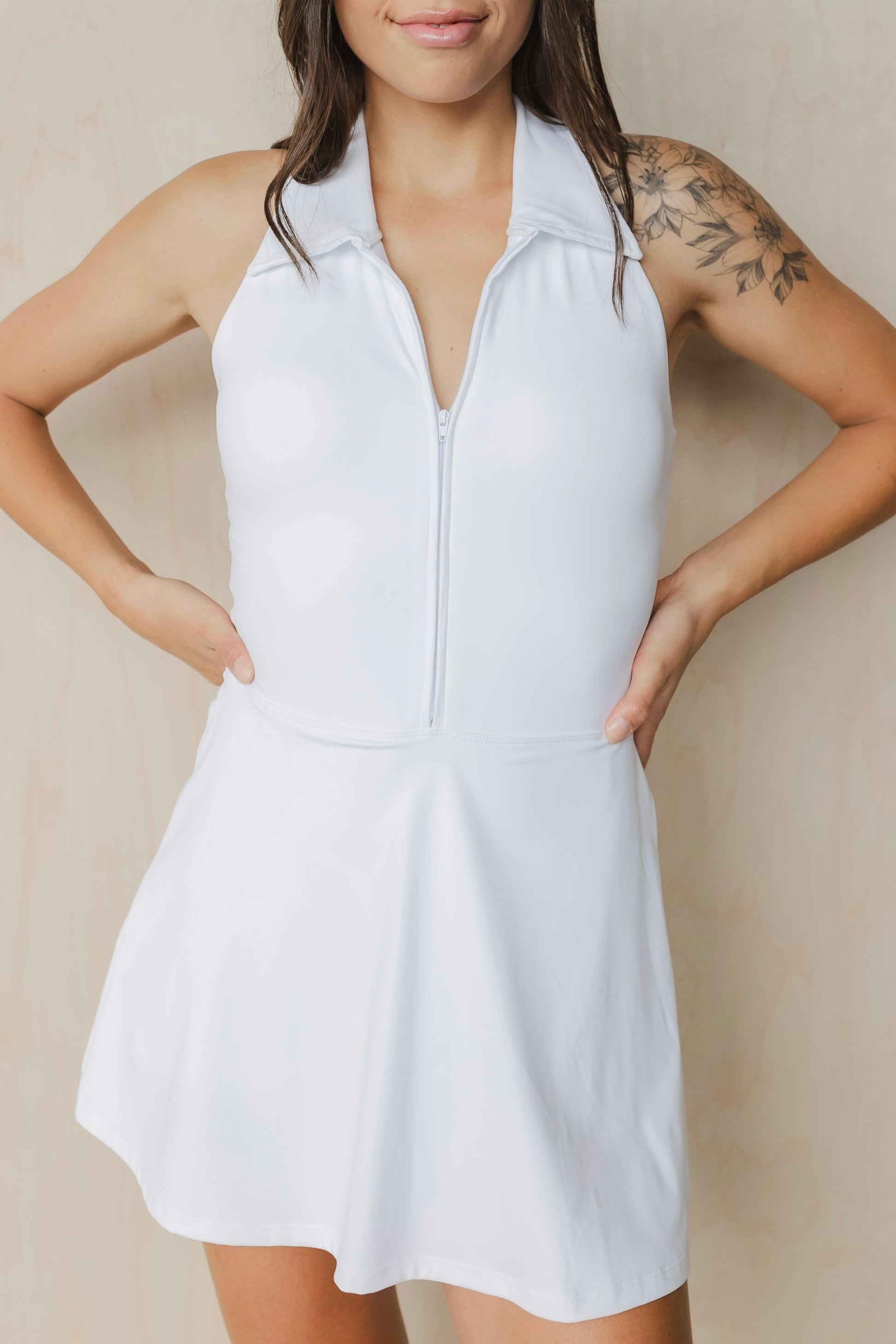front view of woman wearing Tee Time golf dress in white with built-in shorts and collar for yoga and fitness
