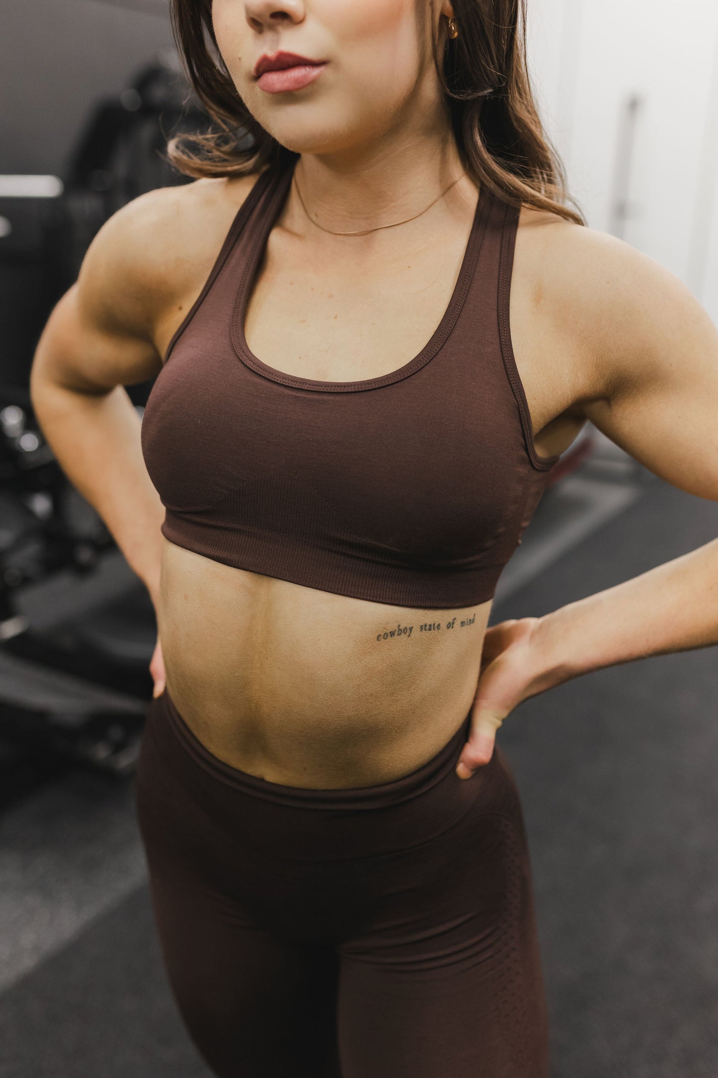 front view of a woman wearing a silhouette seamless sports bra in brown with matching leggings for yoga and fitness