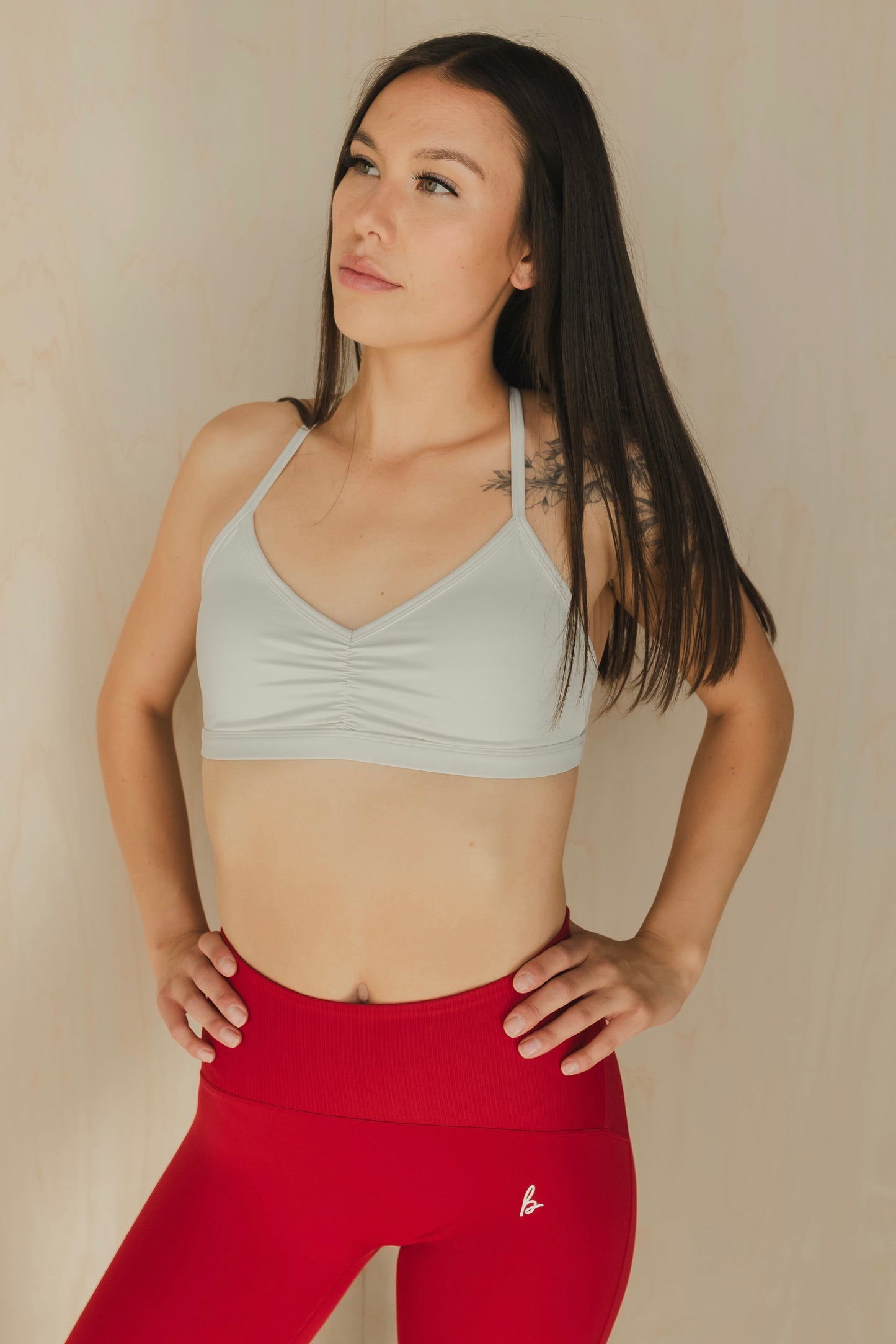 zoomed out view of a woman wearing a mini scrunch sports bra in white smoke for pilates and low impact training