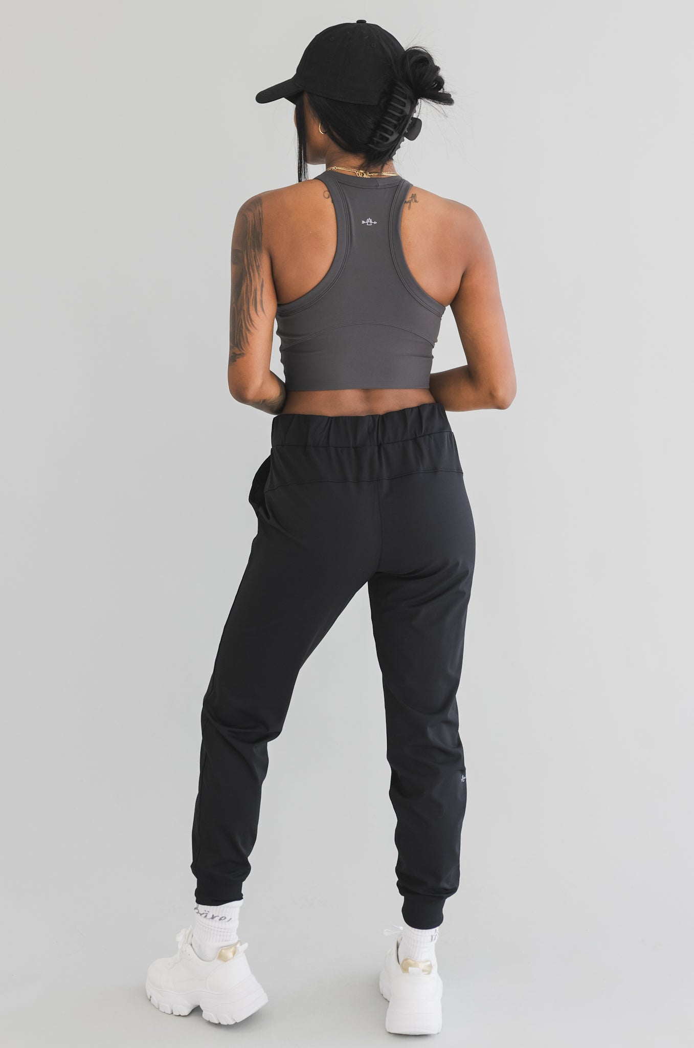 full back view of a woman wearing cuffed ankle jogger in black camo for streetwear and everyday wear
