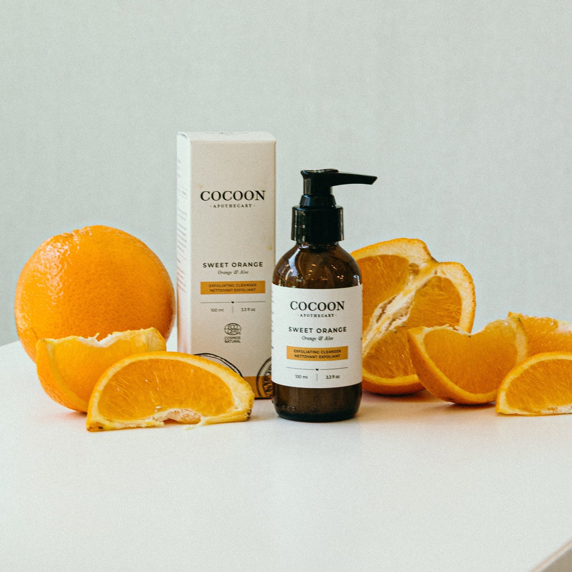 Cocoon Sweet Orange skin cleanser with oranges on a light background
