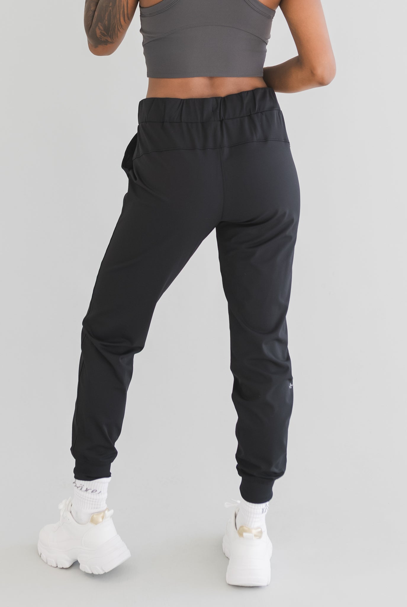 back view of a woman wearing cuffed ankle jogger in black camo for streetwear and everyday wear