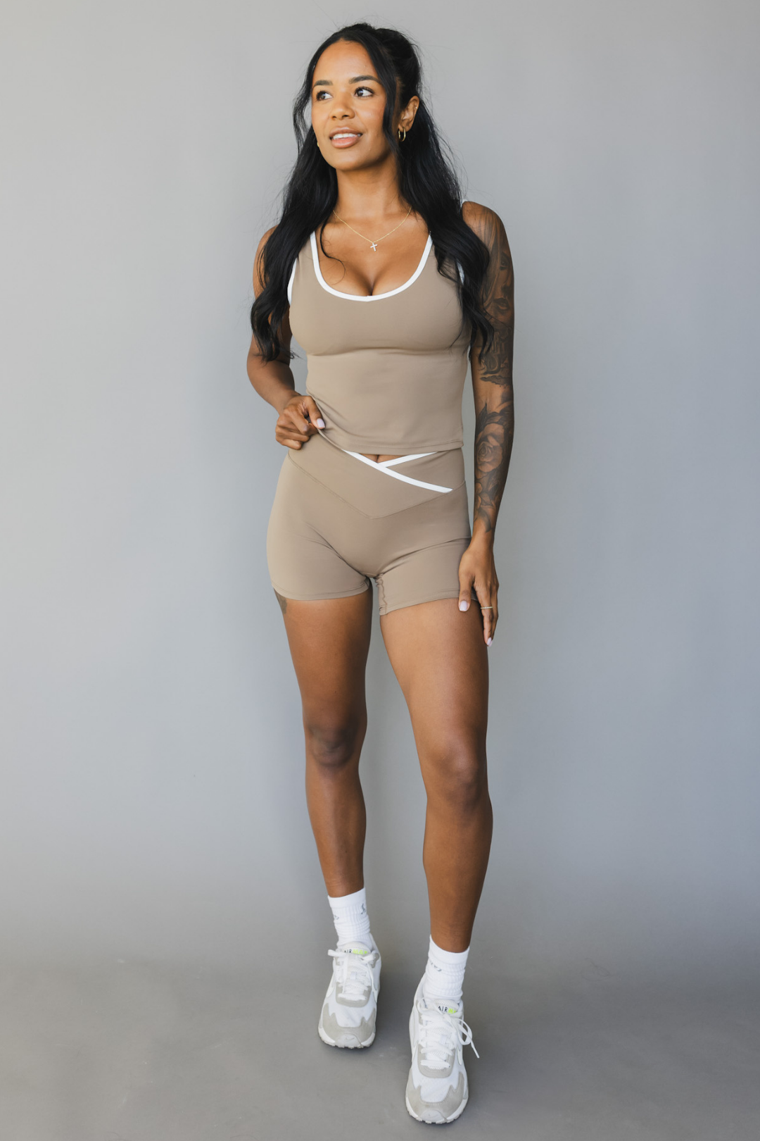 full body front view of a woman wearing Tina shorts in sable brown with white trim and a matching tank top for athletic wear and loungewear
