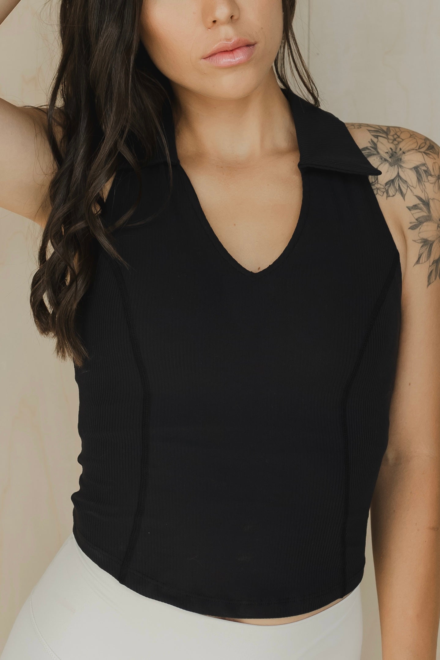 close up view of a woman wearing a Ace tank top in black for golf yoga and activewear