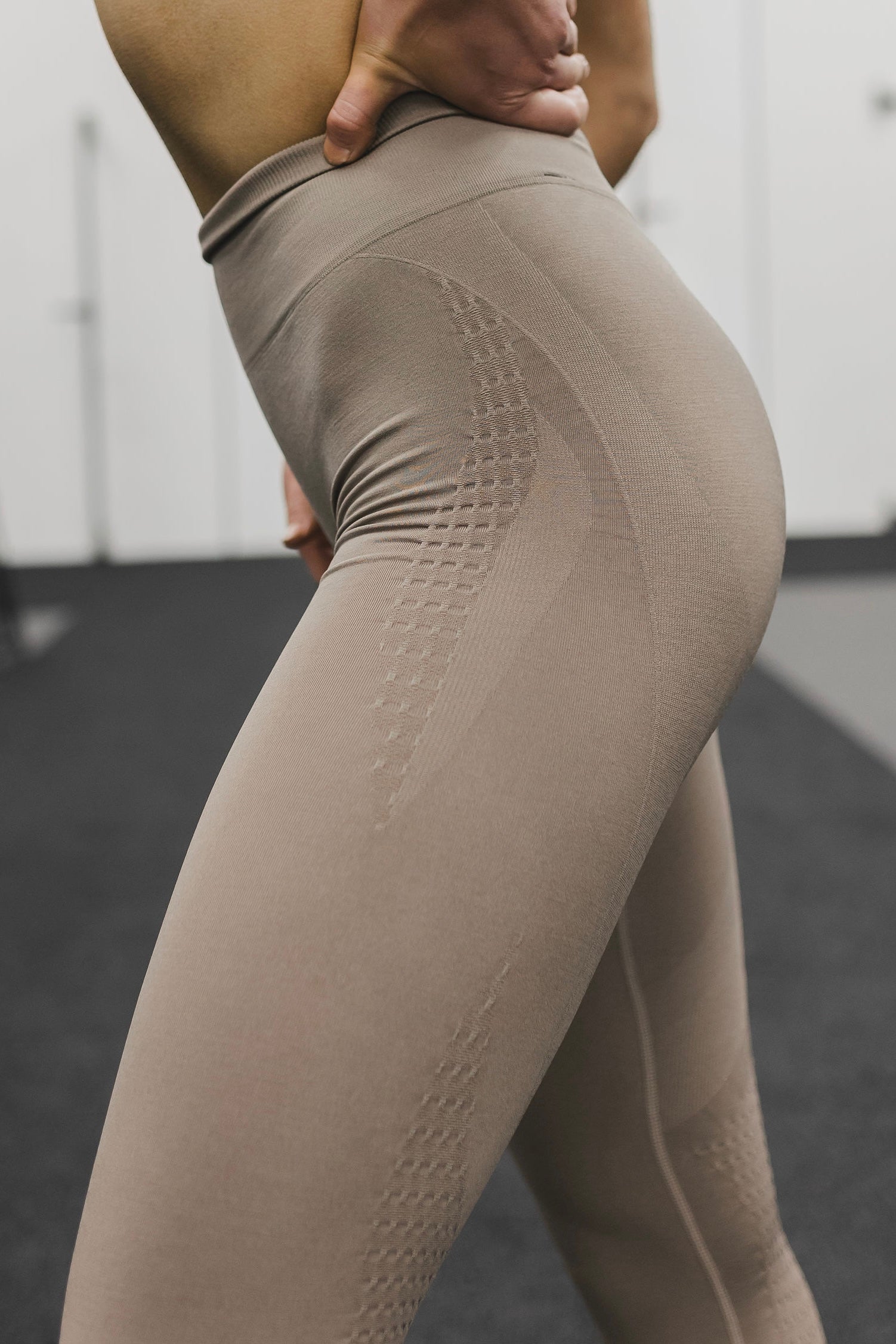 side view of a woman wearing mini scrunch leggings in desert storm for loungewear and athletic wear