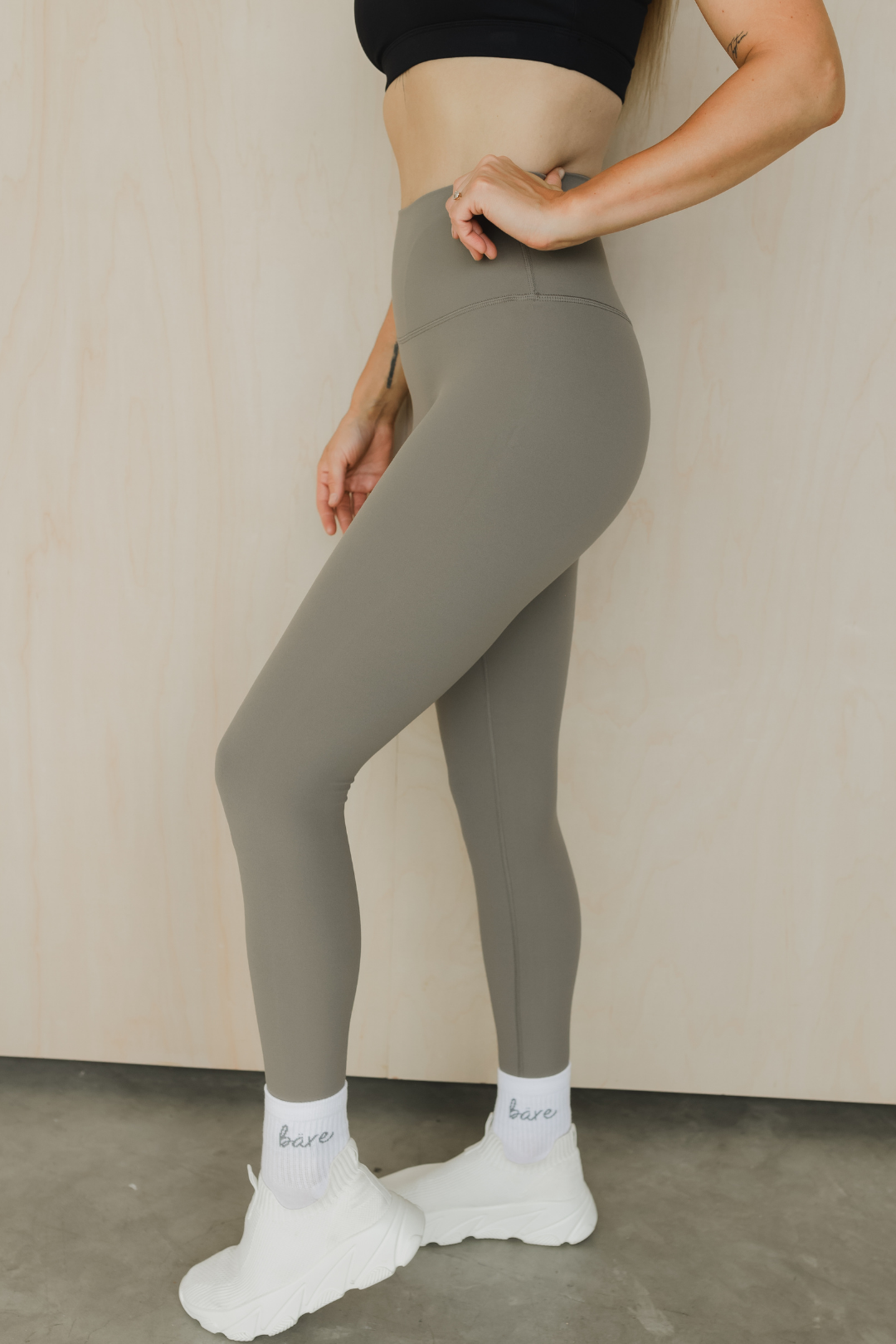 zoomed in side view of a woman wearing 27 inch tall barely there leggings in green grey for pilates and casual athleisure