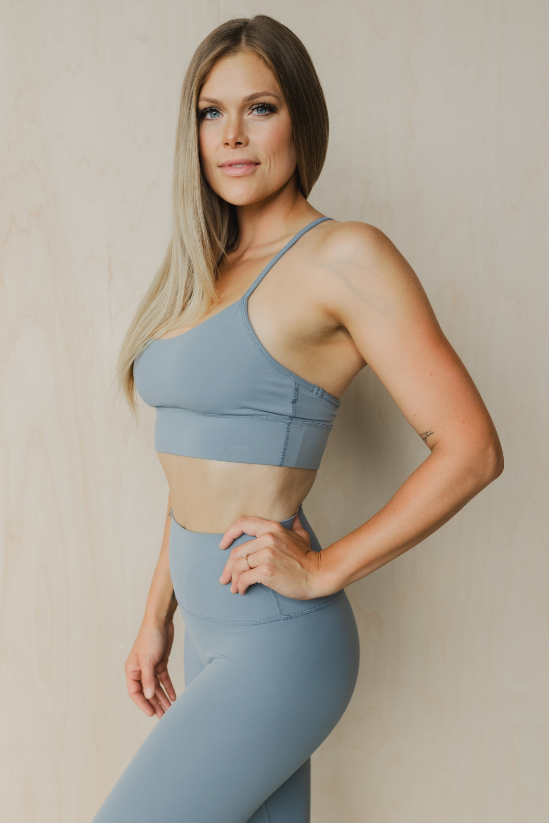 side view of a woman wearing a barely there sports bra in dark slate grey for the gym and activewear
