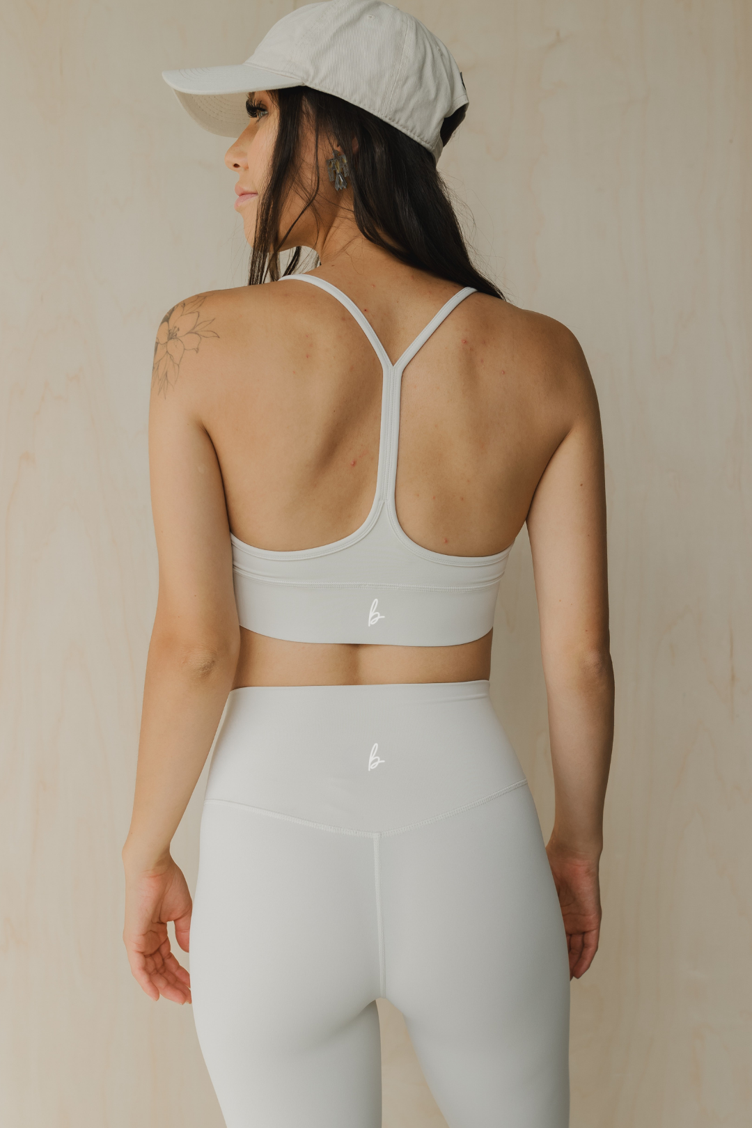 back front view of a woman wearing a barely there sports bra in dove white for yoga and studio workouts