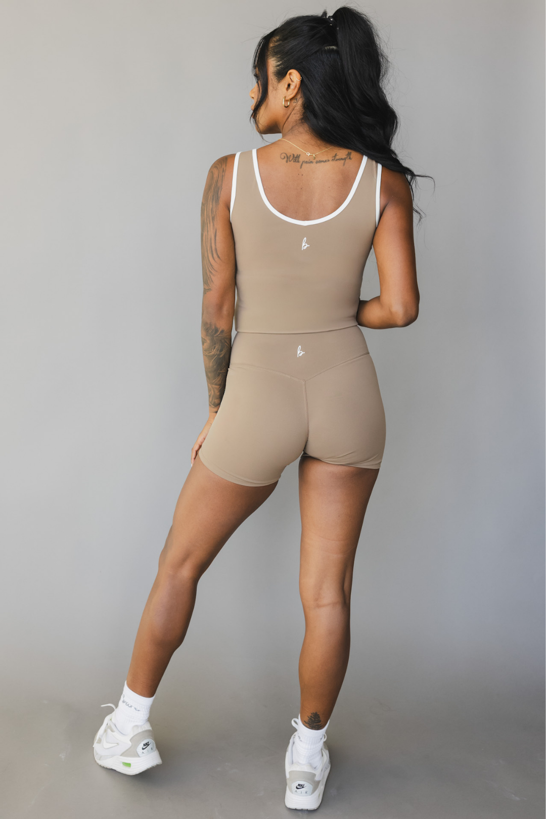 full body back view of a woman wearing Tina shorts in sable brown with white trim and a matching tank top for athletic wear and loungewear