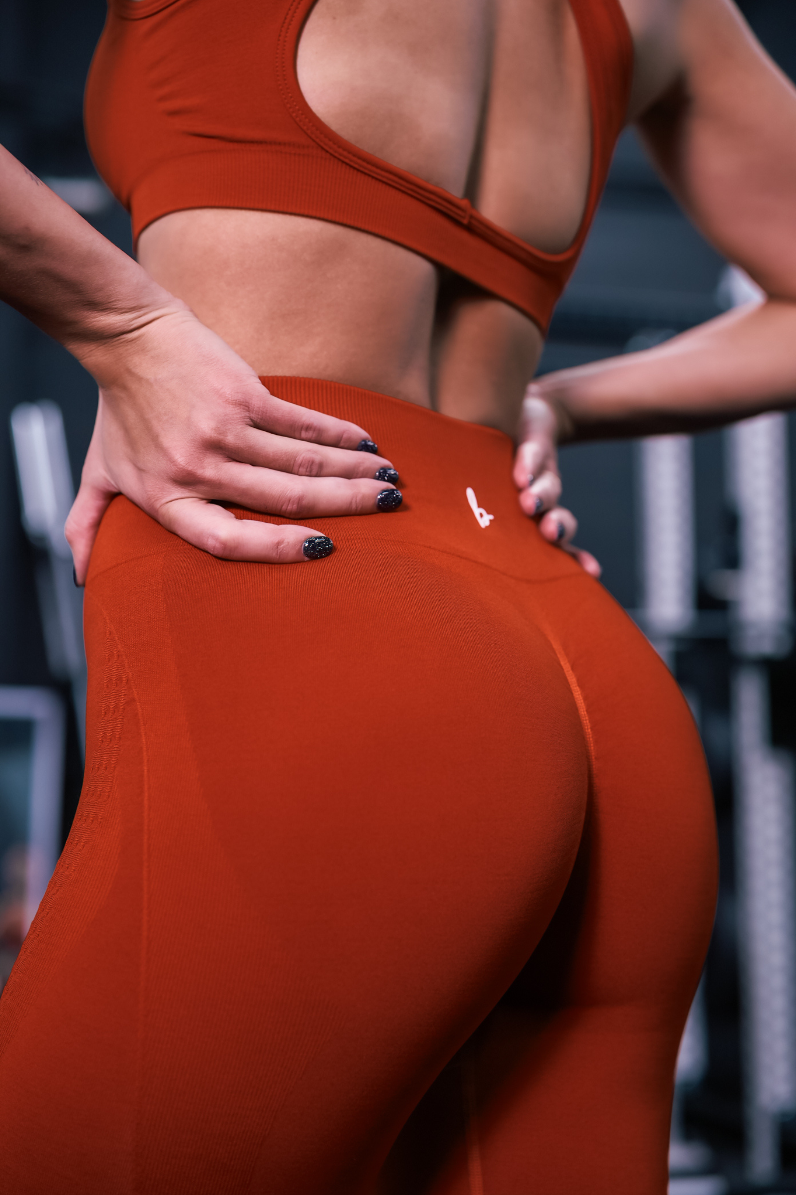 close up back view of a woman wearing mini scrunch leggings in vermillion for hot yoga and studio workouts