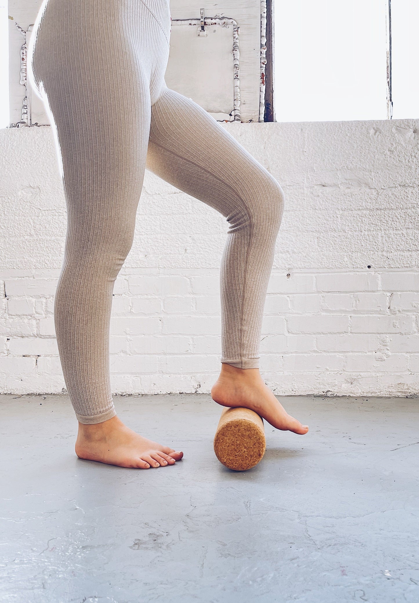 person stepping on a cork yoga roller