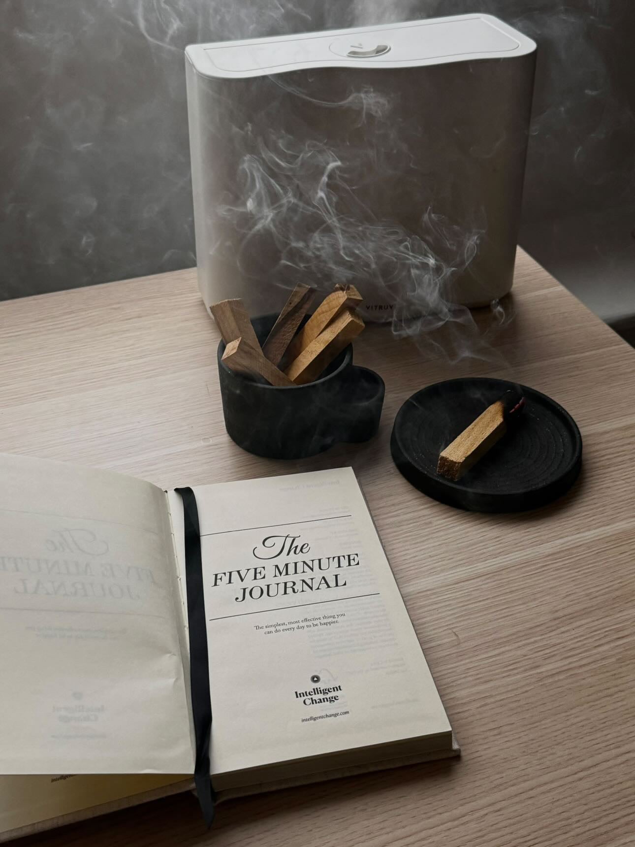 Vulcan ceramic bowl incense stick holder on a table with a diffuser and wooden sticks.