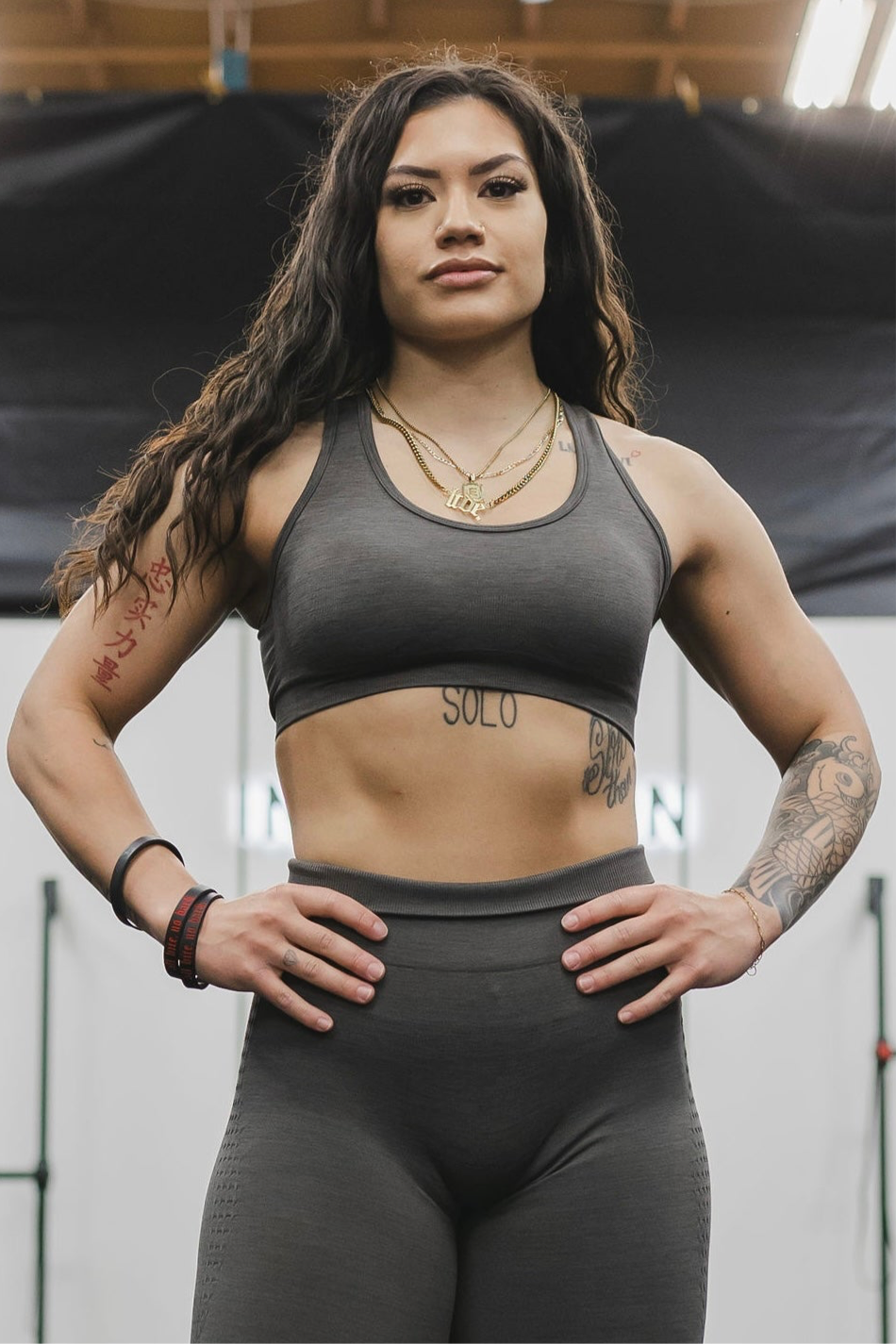 close up front view of a woman wearing a silhouette seamless sports bra in dark grey with matching leggings for yoga and fitness
