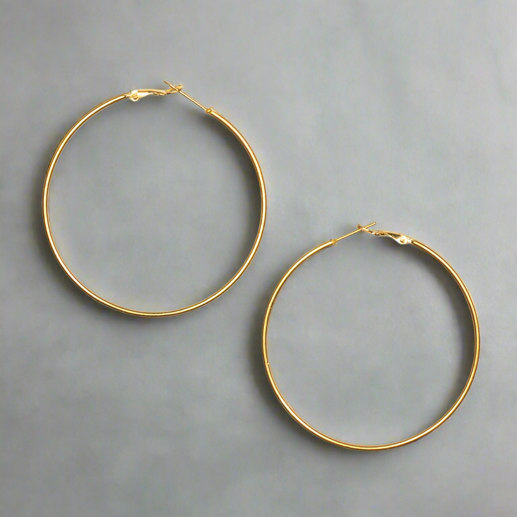 Gold hoop earrings on a gray background