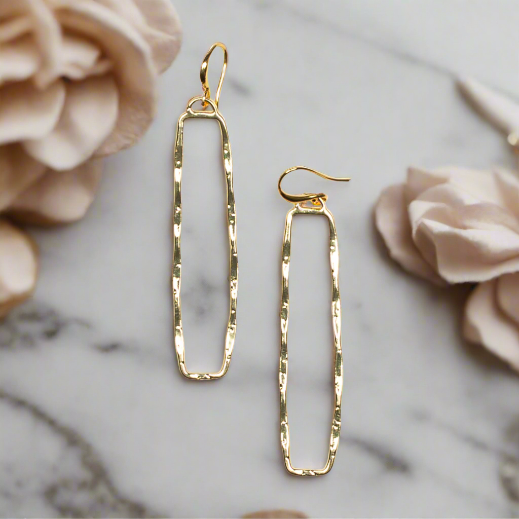 Gold plate rectangular drop earrings geometric minimalist jewelry on a marble surface