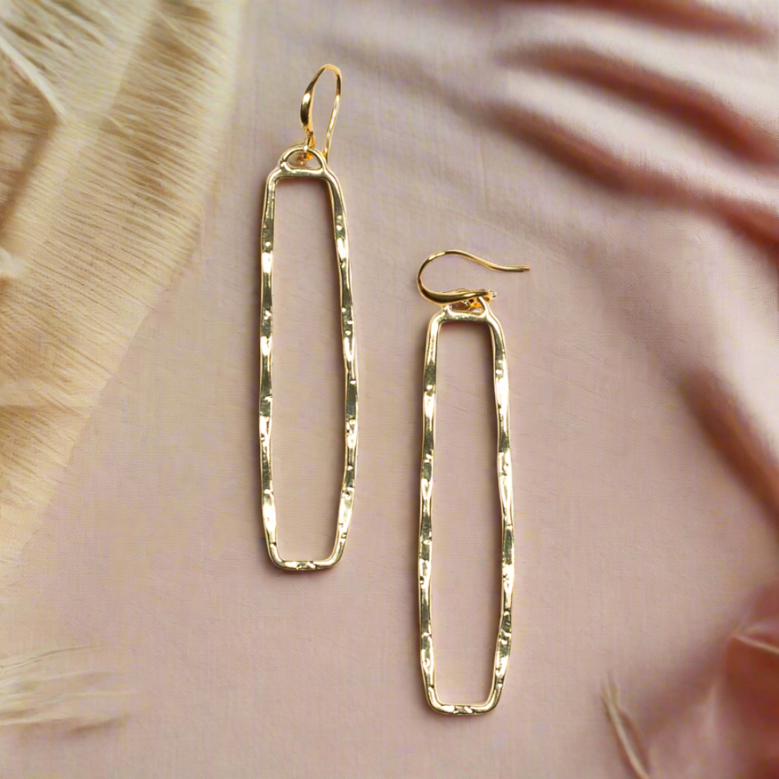 Gold plate rectangular drop earrings geometric minimalist jewelry on a pink background