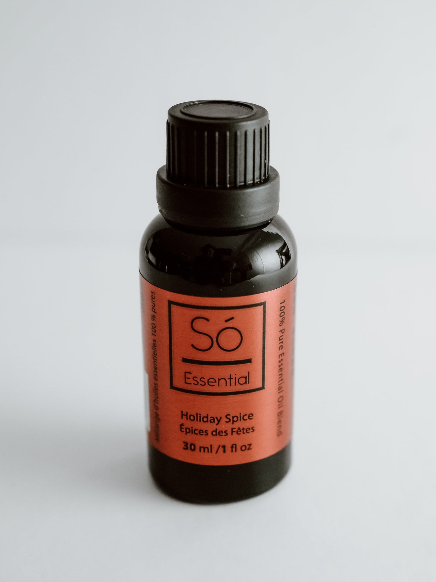 Essential Oil Bottle of Sö Essential Holiday Spice on a light gray background